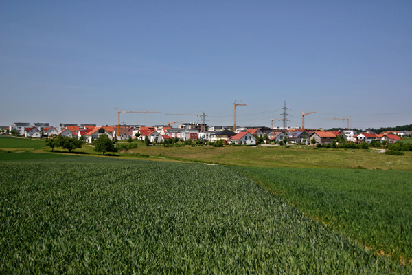 Foto einer Ortschaft von einem Feld heraus