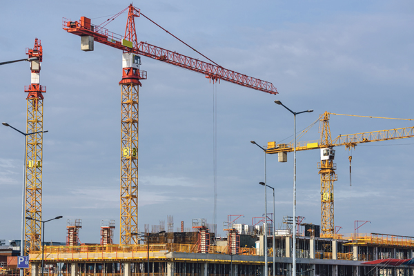 gelb-rote Kräne über Baustelle