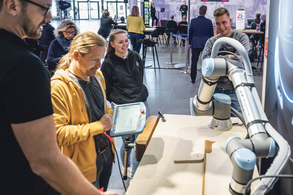 Beratung und Vorführung im Bereich Robotik & Automation im Schreinerhandwerk am Stand von J+H auf der ZUKUNFT HANDWERK. Roboterarm zum Schleifen von Holz.